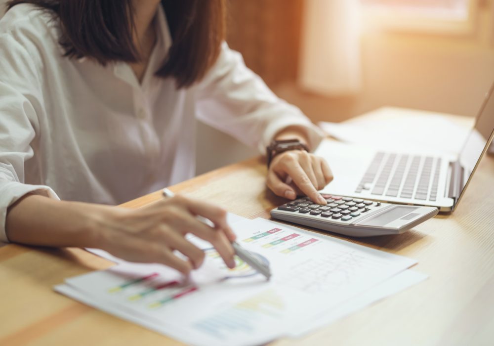 Businesswoman in office and use computer and calculator to perform financial accounting